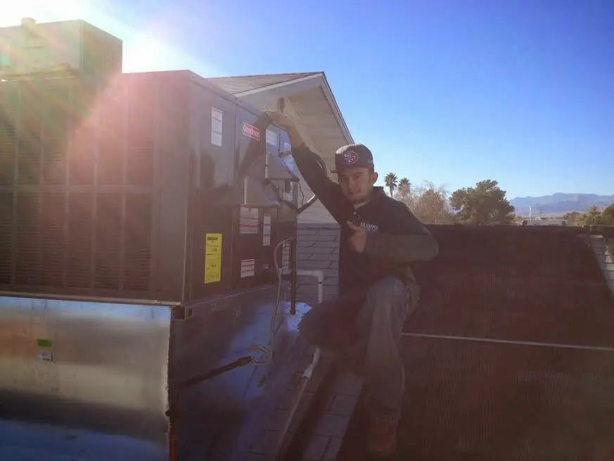 HVAC technician performing AC Tune-Up on a rooftop unit in Oak Ridge